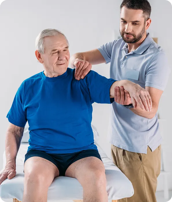 Physiothérapeute traitant l'épaule d'une personne âgée à domicile